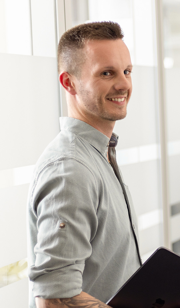 Ein Mitarbeiter der Insolvenzkanzlei lächelt freundlich in die Kamera